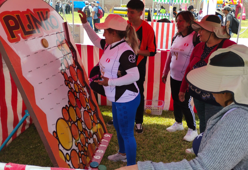 Puesto de feria tipo kermesse con decoración de rayas rojas y blancas para eventos corporativos.