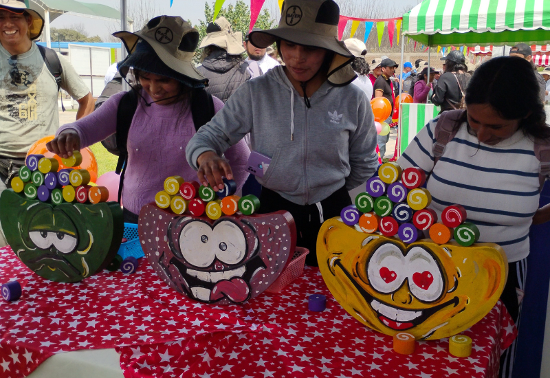Decoración temática de kermesse con banderines y juegos tradicionales para integración.