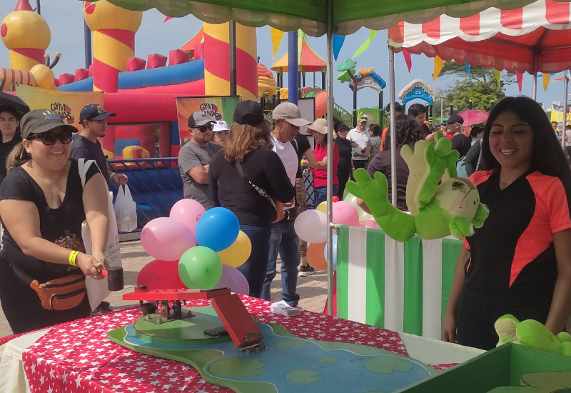 Decoración temática de kermesse con banderines y juegos tradicionales para integración.